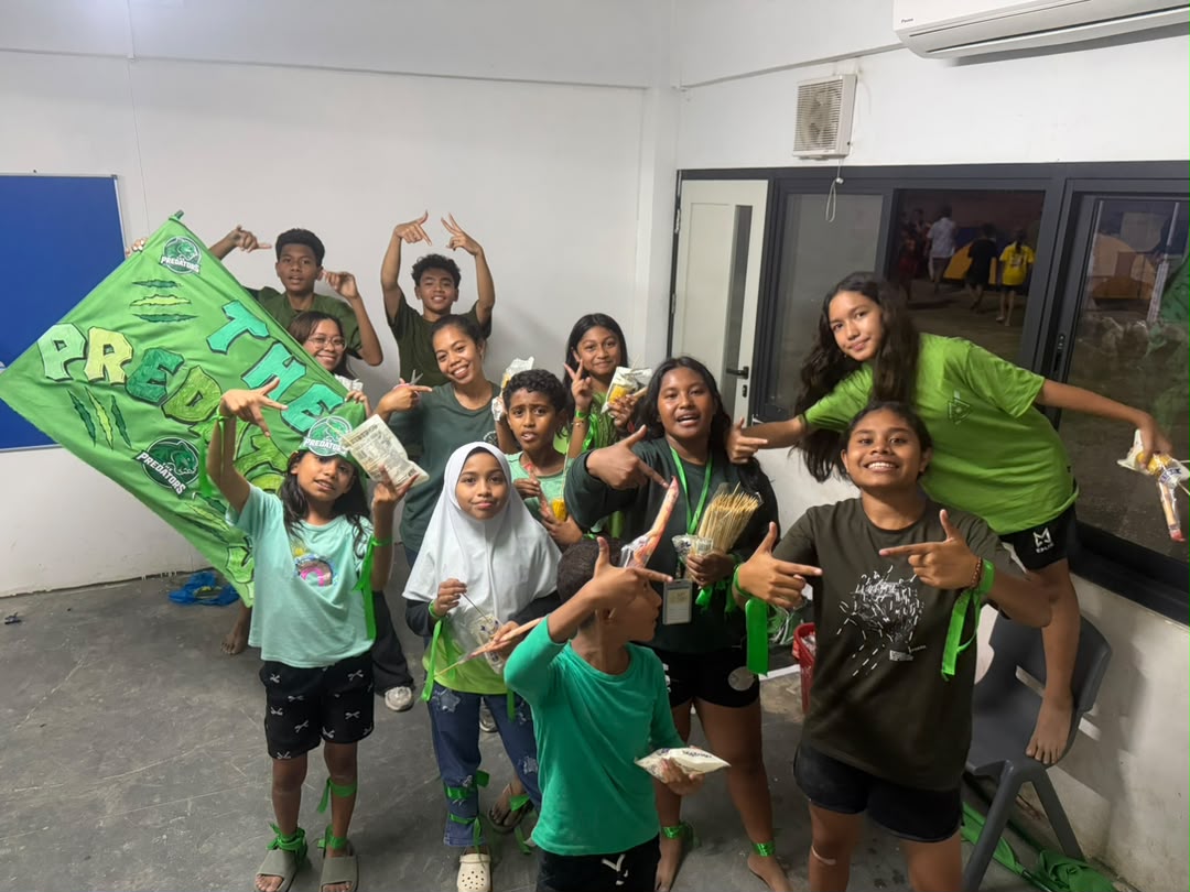 The green team celebrating with their banner