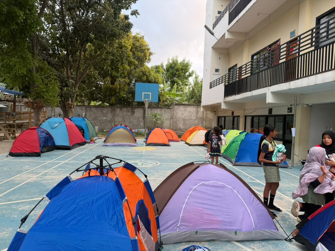 Rows of colourful camping tents set up on the school courtyard